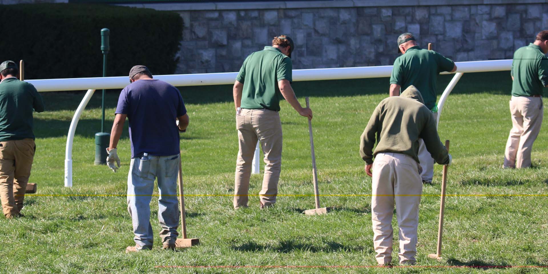 An action shot of Racinginsider team members tamping down turf divots.